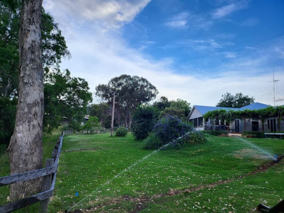 A Large Lawn with A House in The Background and A Fence in The Foreground — Peel Irrigation & Water Supplies in Taminda, NSW