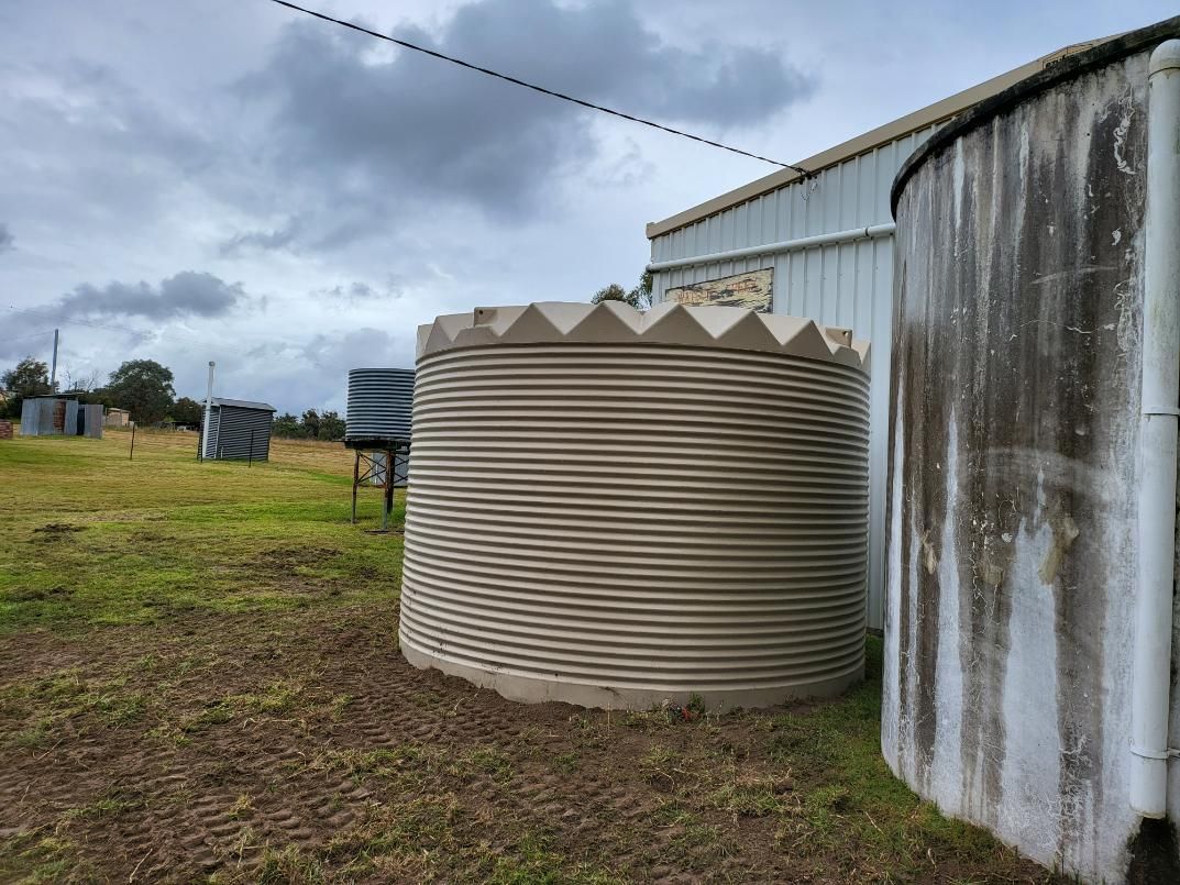 Two Water Tanks Are Sitting Next to Each Other in A Field — Peel Irrigation & Water Supplies in Taminda, NSW
