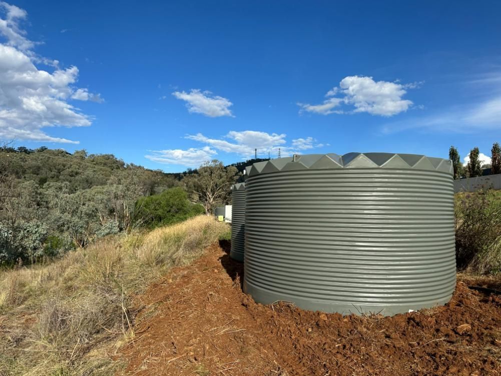 A Large Water Tank Is Sitting in The Middle of A Dirt Field — Peel Irrigation & Water Supplies in Taminda, NSW