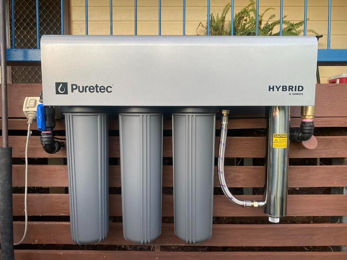 Puretec Hybrid Water Filter is Attached to a Wooden Fence — Peel Irrigation & Water Supplies in Tamworth, NSW