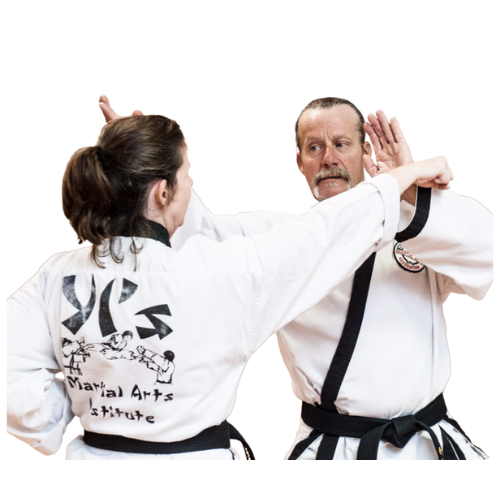 A man and a woman are standing next to a young boy in karate uniforms