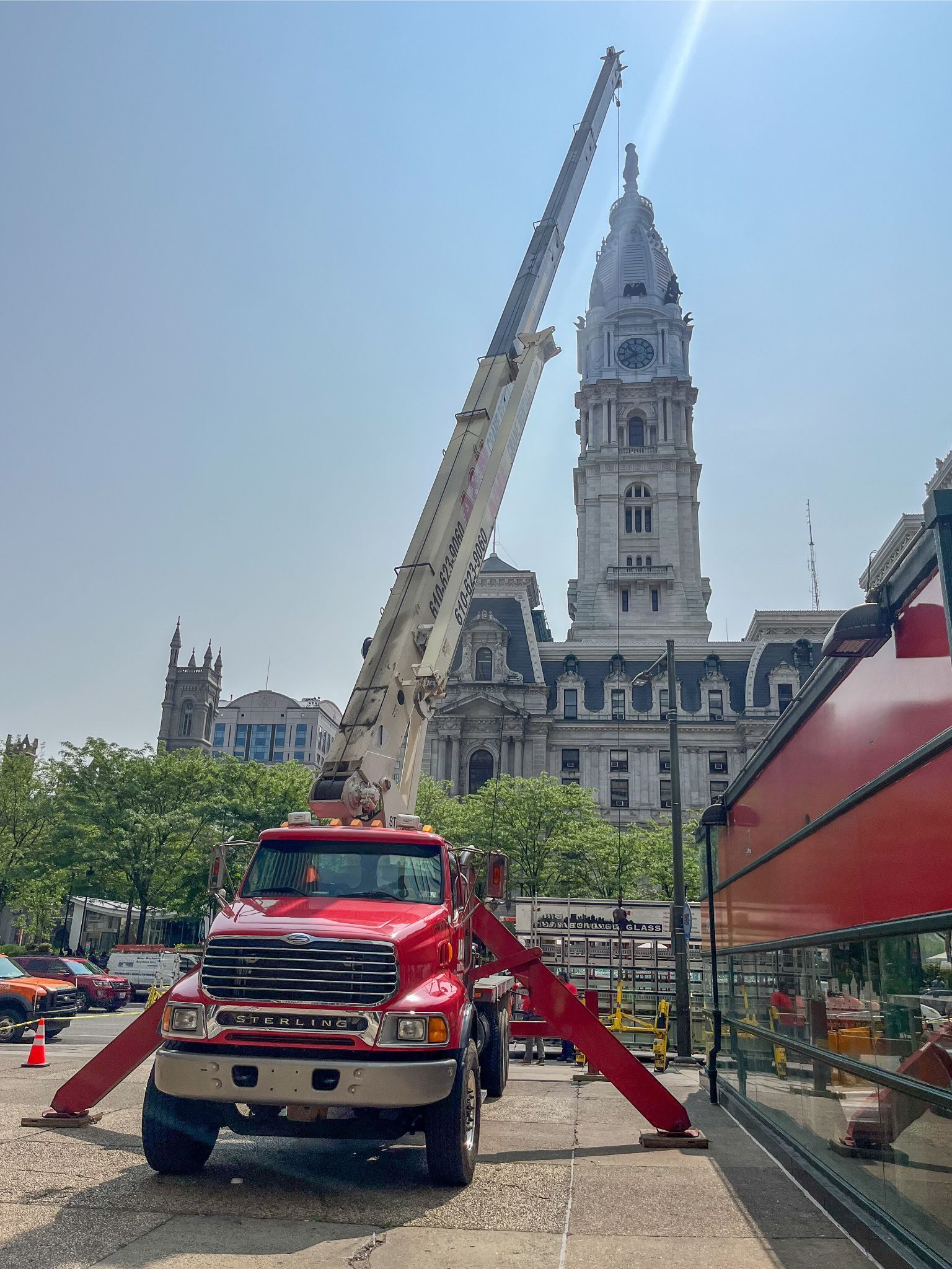 A red A&N Crane Rental mobile crane is parked in front of Philadelphia City Hall. 