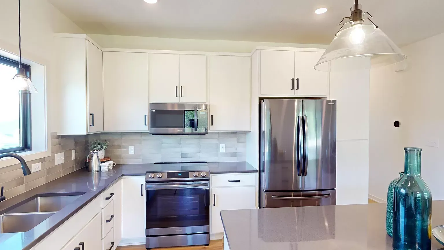 A kitchen with white cabinets and stainless steel appliances
