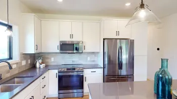 A kitchen with white cabinets and stainless steel appliances