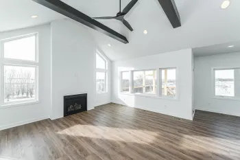 An empty living room with hardwood floors and a ceiling fan.
