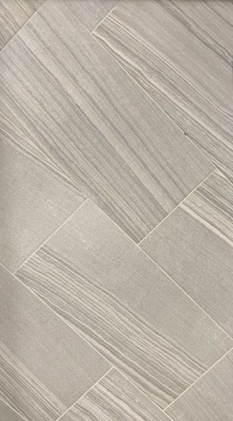 A close up of a white tile floor with a wood grain texture.