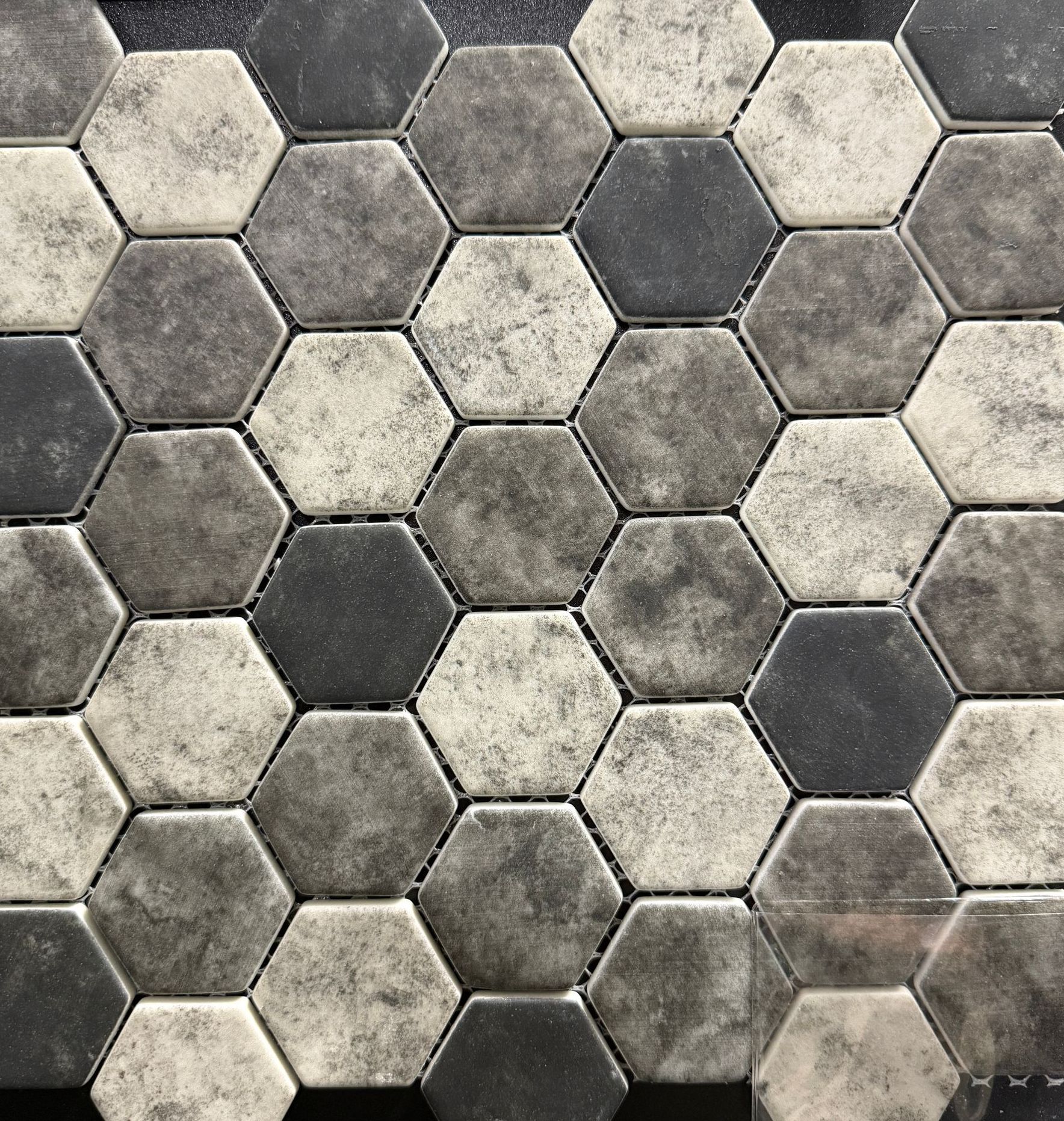 Hexagon tile mosaic in shades of gray and white.