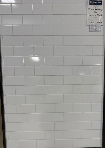A close up of three white tiles on a wall.
