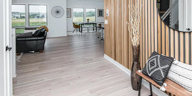 A hallway in a house with a wooden wall and a bench.