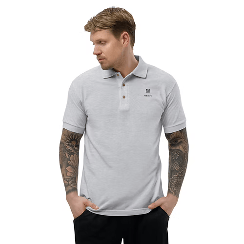 A man with a tattoo on his arm is wearing a red polo shirt.