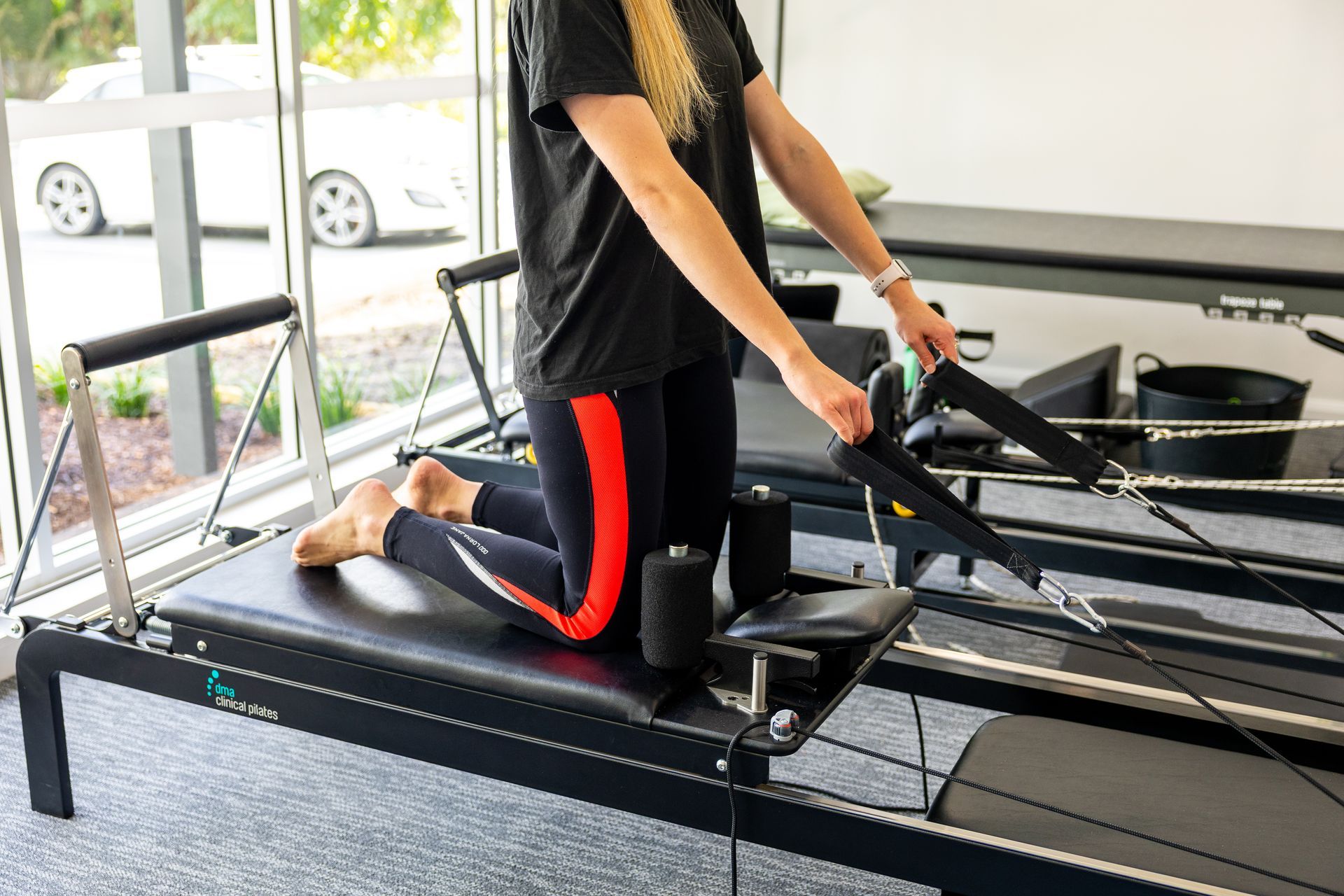 Person using a cable machine during a workout, lying on a bench and pulling a bar down. — Forerunner Physio In Taree, NSW