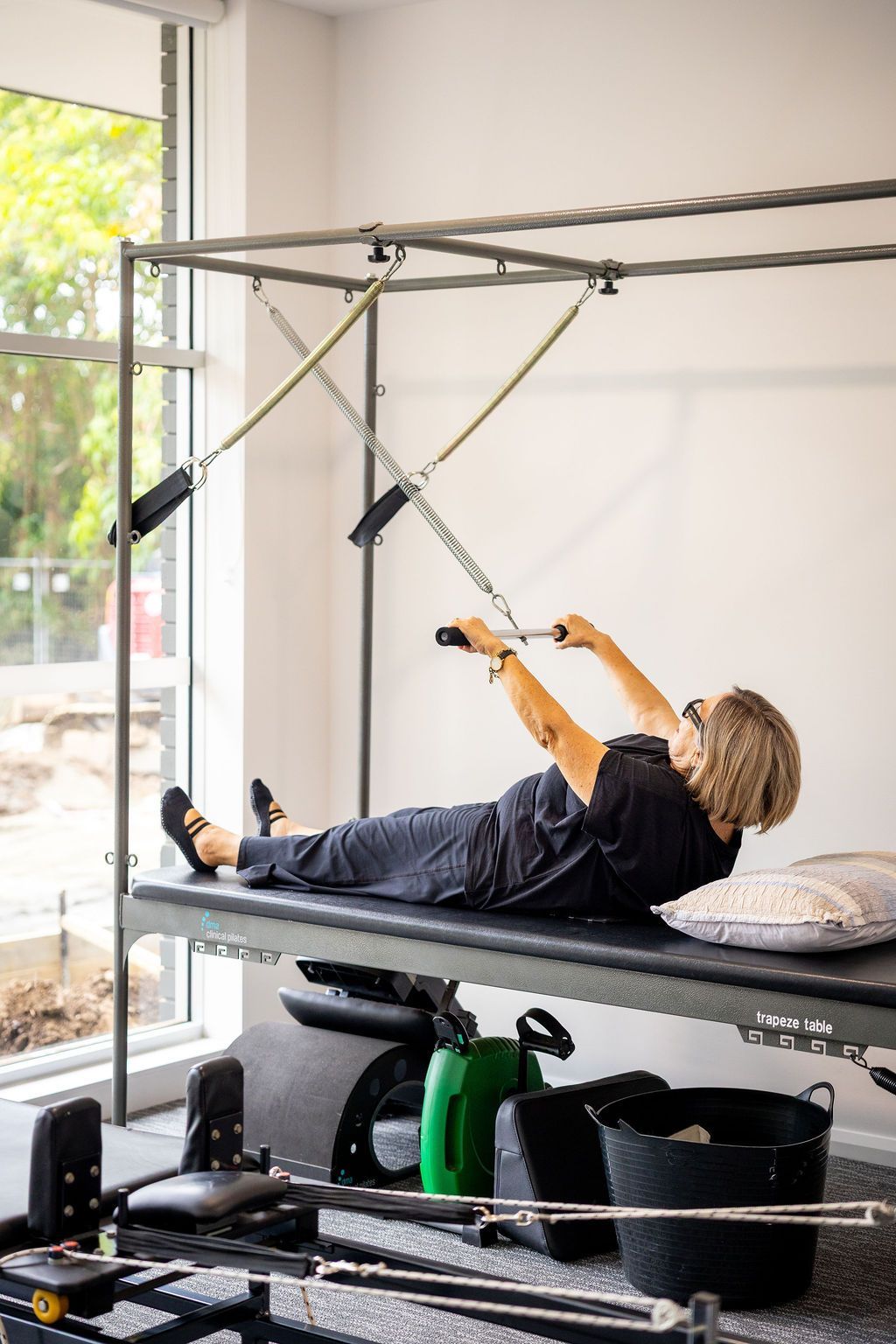 Person exercising on a Pilates reformer in a bright studio — Forerunner Physio In Taree, NSW