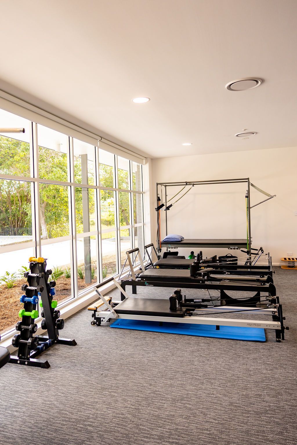 Bright room with windows and a partially assembled machine on a carpeted floor — Forerunner Physio In Taree, NSW