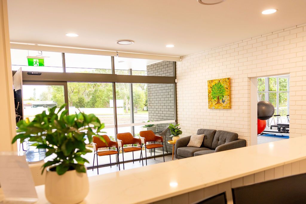 Bright modern lobby with plants, seating, large windows, and a reception counter — Forerunner Physio In Taree, NSW