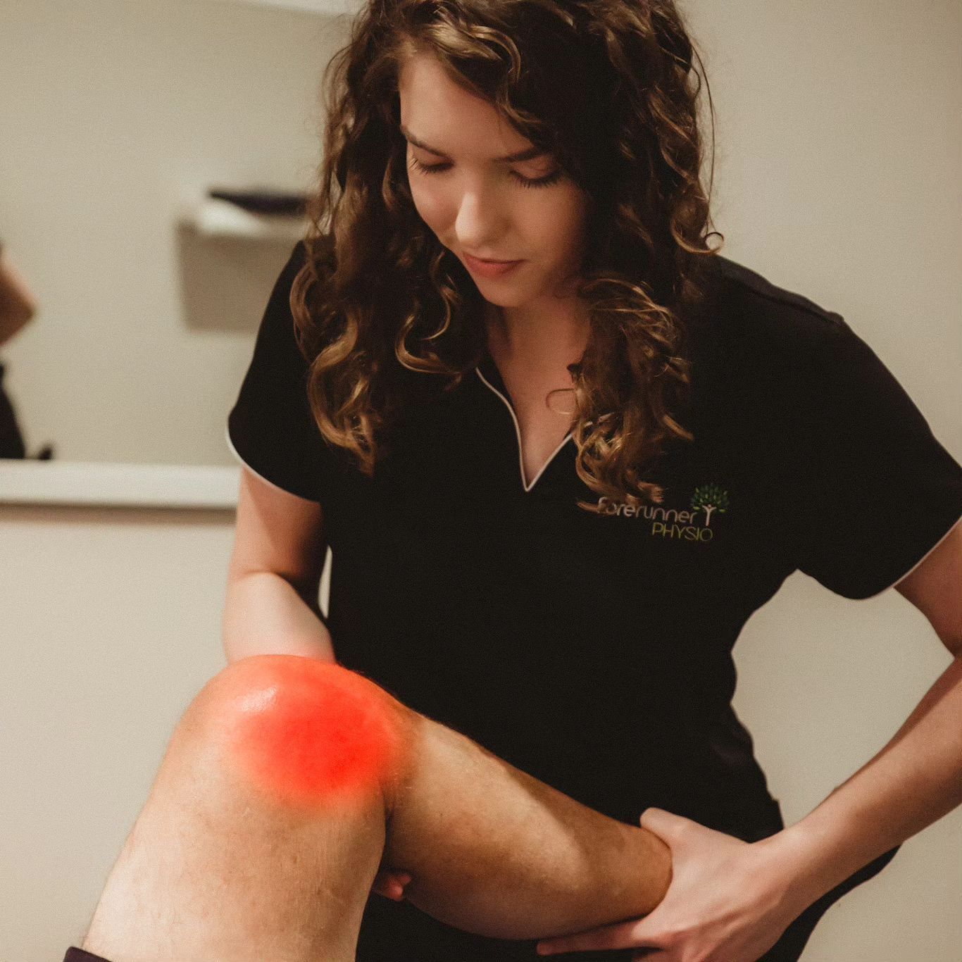 Physiotherapist Examining a Knee With Red Highlighting Indicating Pain — Forerunner Physio In Taree, NSW