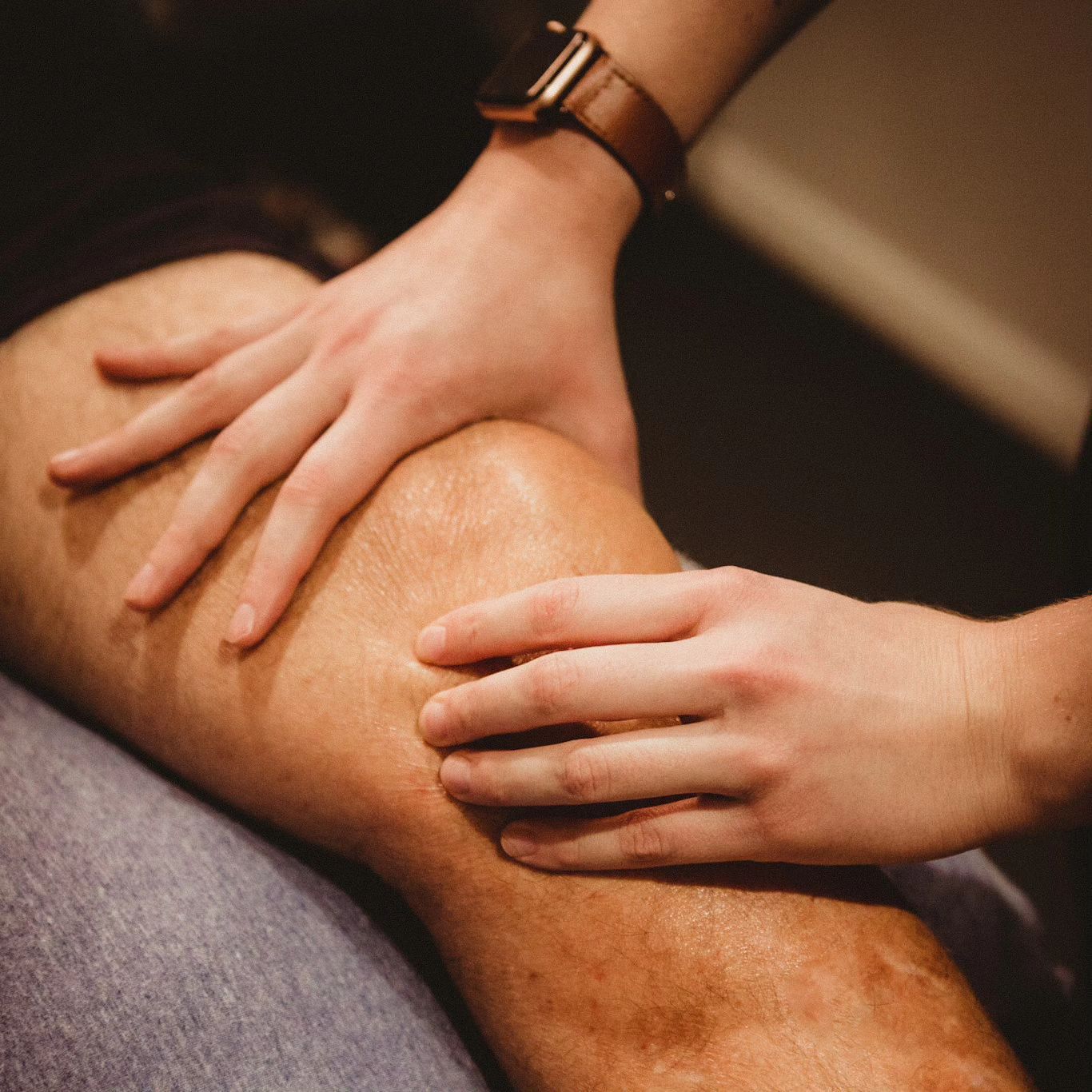 Hands gently massage a person’s leg, with a watch on one wrist. — Forerunner Physio In Taree, NSW