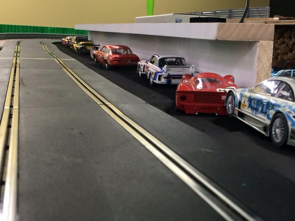Slot Cars Lined Up On A Track, A White Wall On The Right — Midtown Hobbies In Lismore, NSW