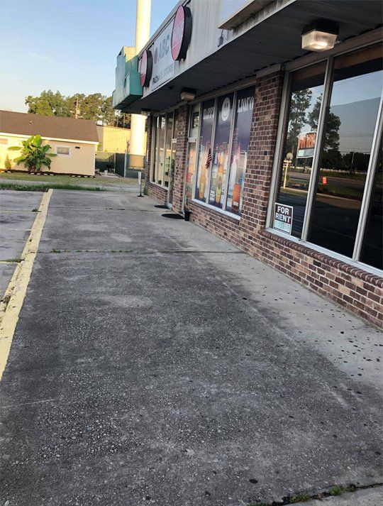 A brick building with a sidewalk in front of it