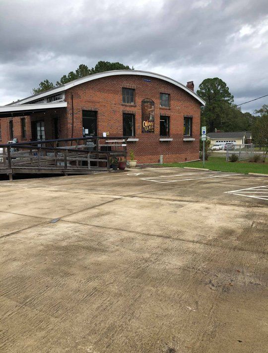A brick building with a curved roof is in a parking lot
