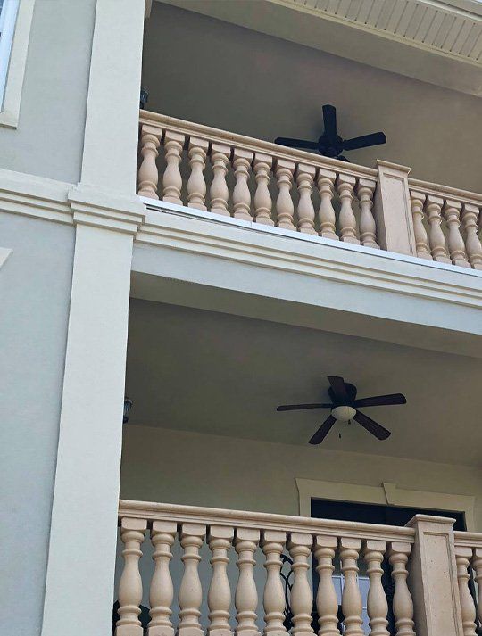 A balcony with a railing and a ceiling fan