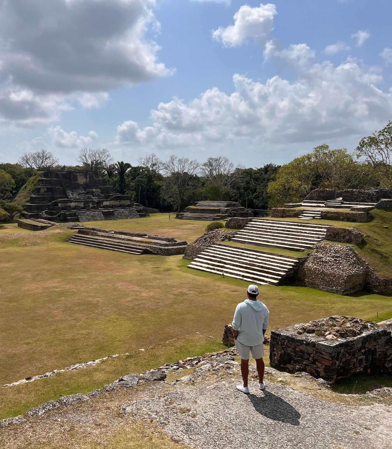Man overlooking ancient Mayan ruins in sunny Belize.