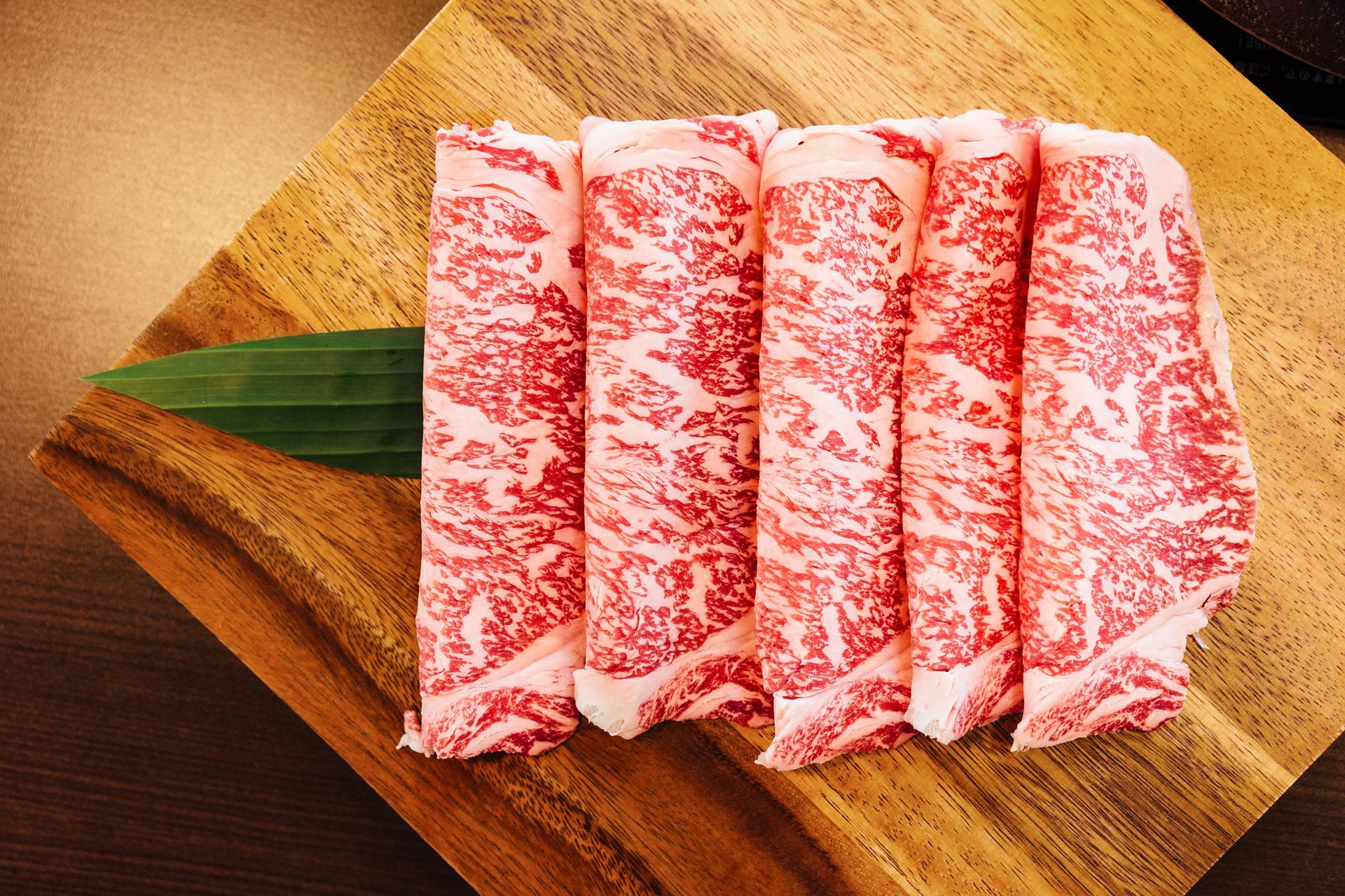 A piece of meat is sitting on a wooden cutting board.