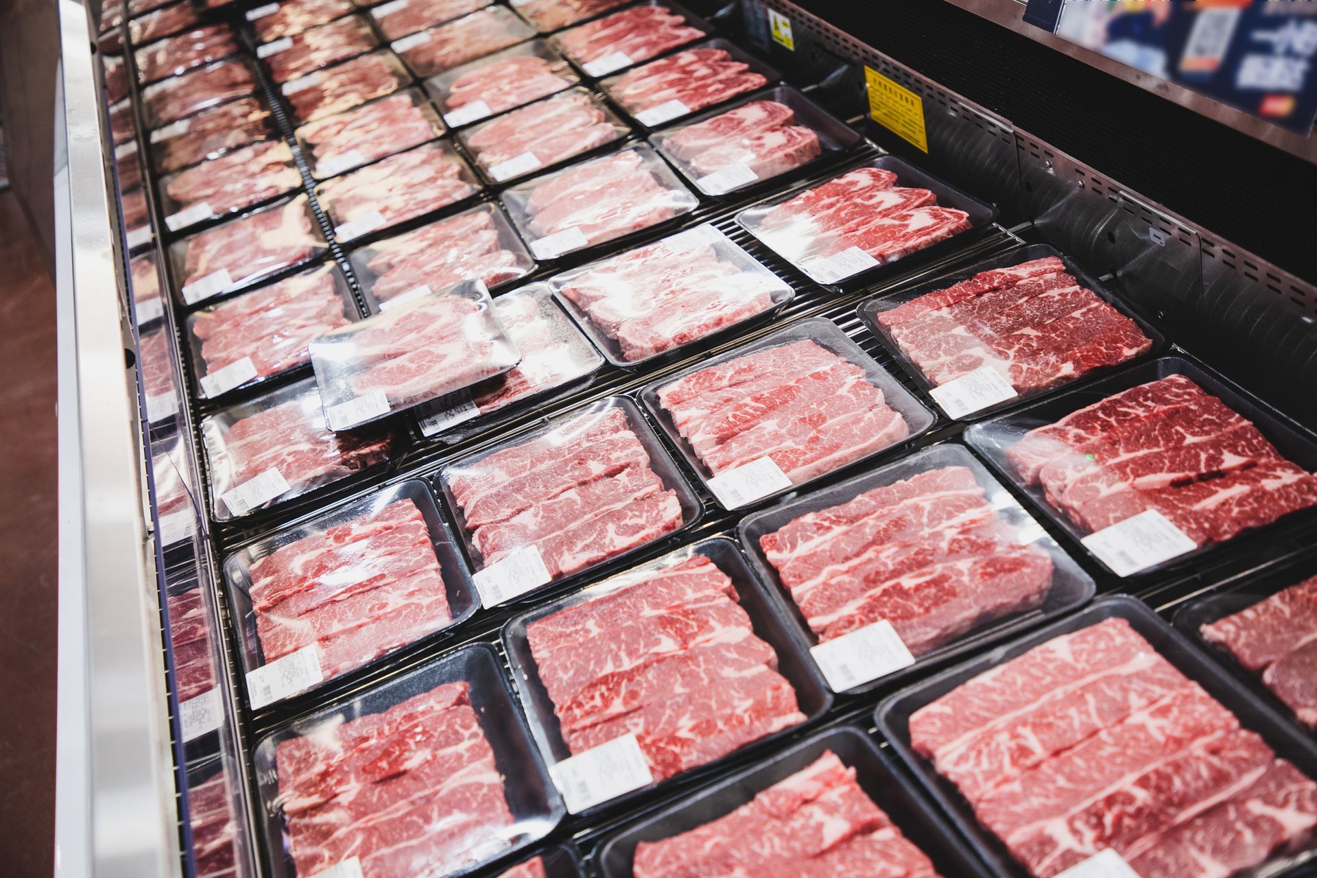 A variety of meats are on display in a butcher shop