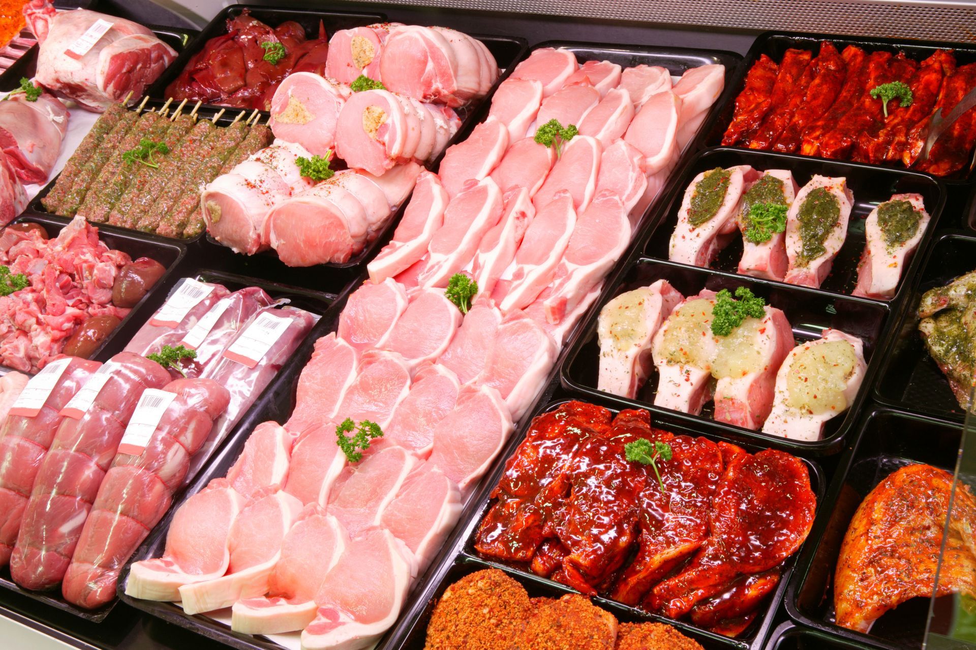 A variety of meats are on display in a butcher shop