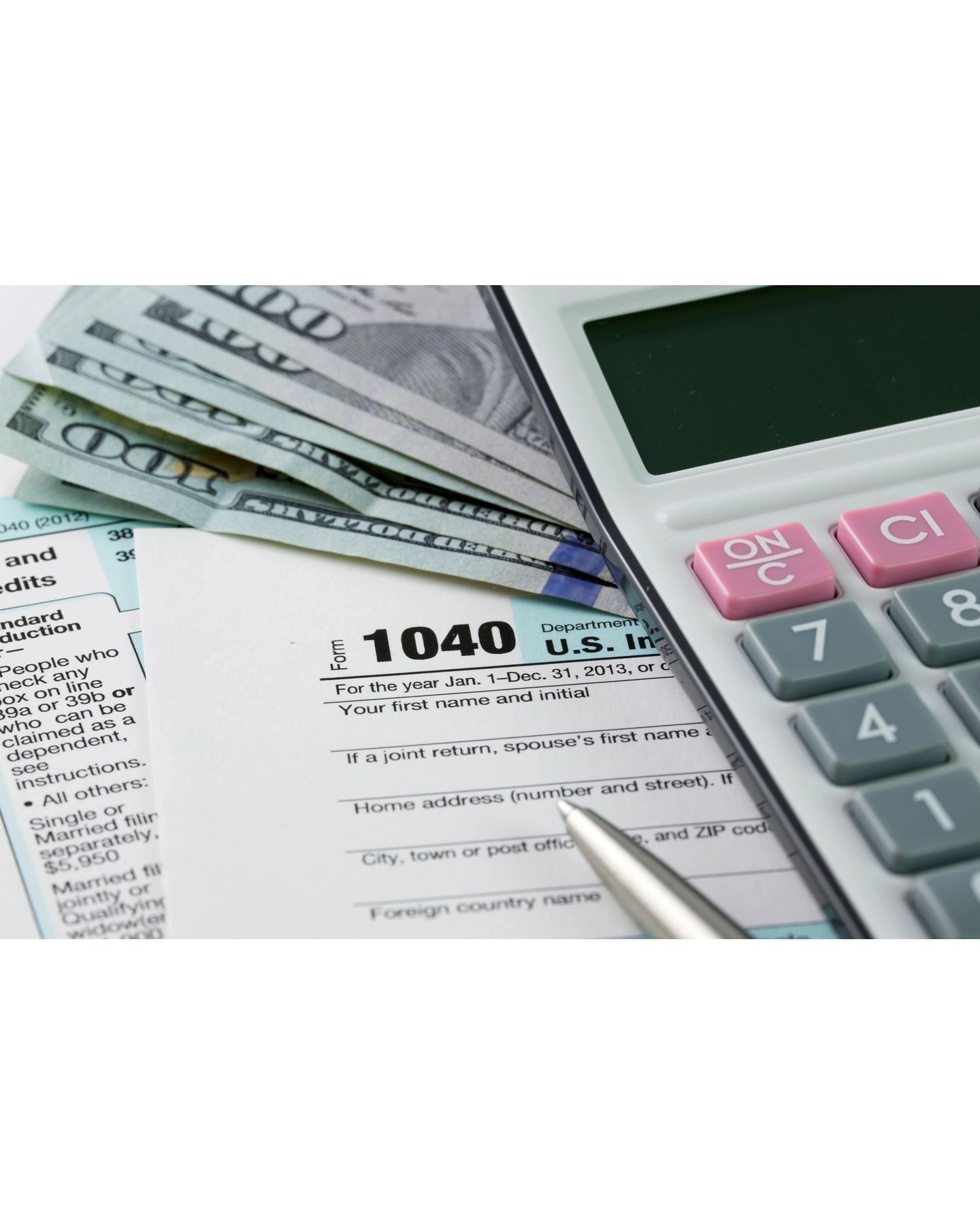 A 1040 tax form is next to a calculator and money