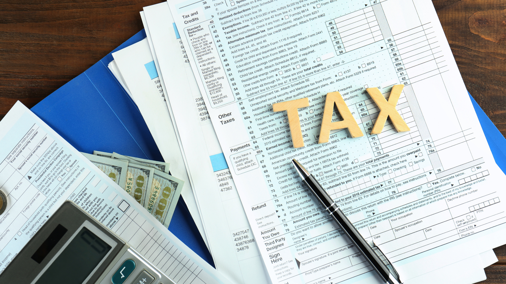 A pen is sitting on top of a pile of tax forms.