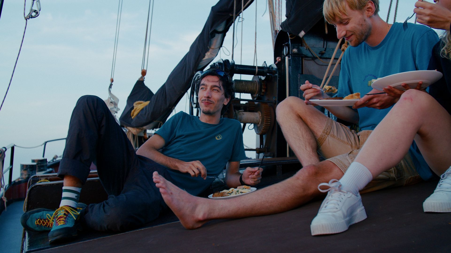 Menschen essen auf einem Bootsdeck in der Dämmerung.