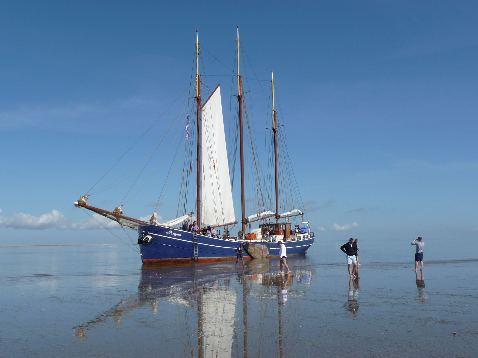 Traditional Dutch sailing ship dried out on the Wadden Sea mudflats during a Netherlands sailing trip.