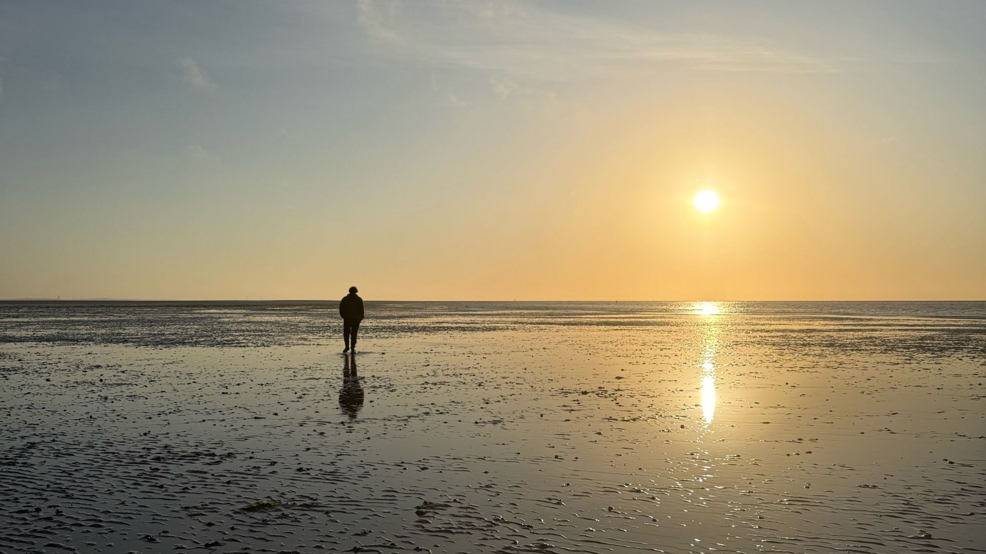 Traditional sailing ship dried out on a sandbank at sunset in the Dutch Wadden Sea