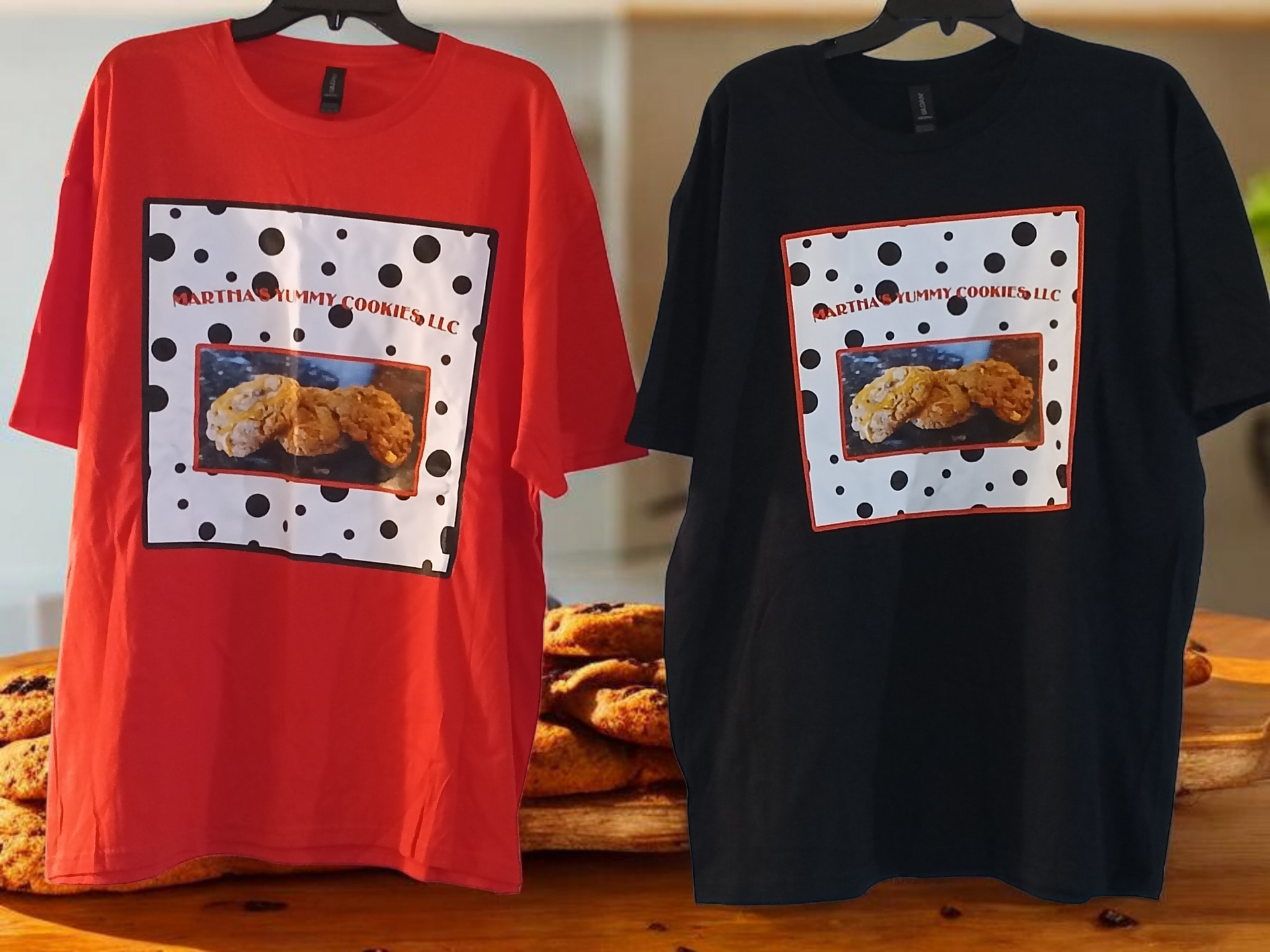 A red and a black T-shirt, both displaying a square graphic of cookies on a dalmatian-spotted background.