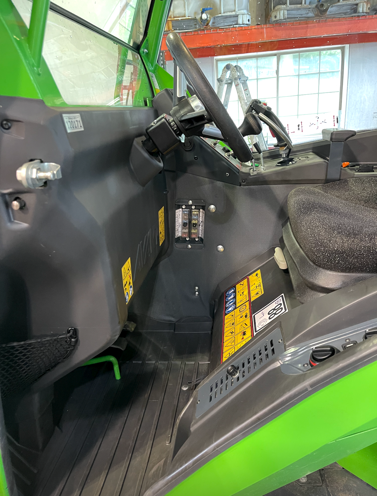the inside of a green and black vehicle with the door open .