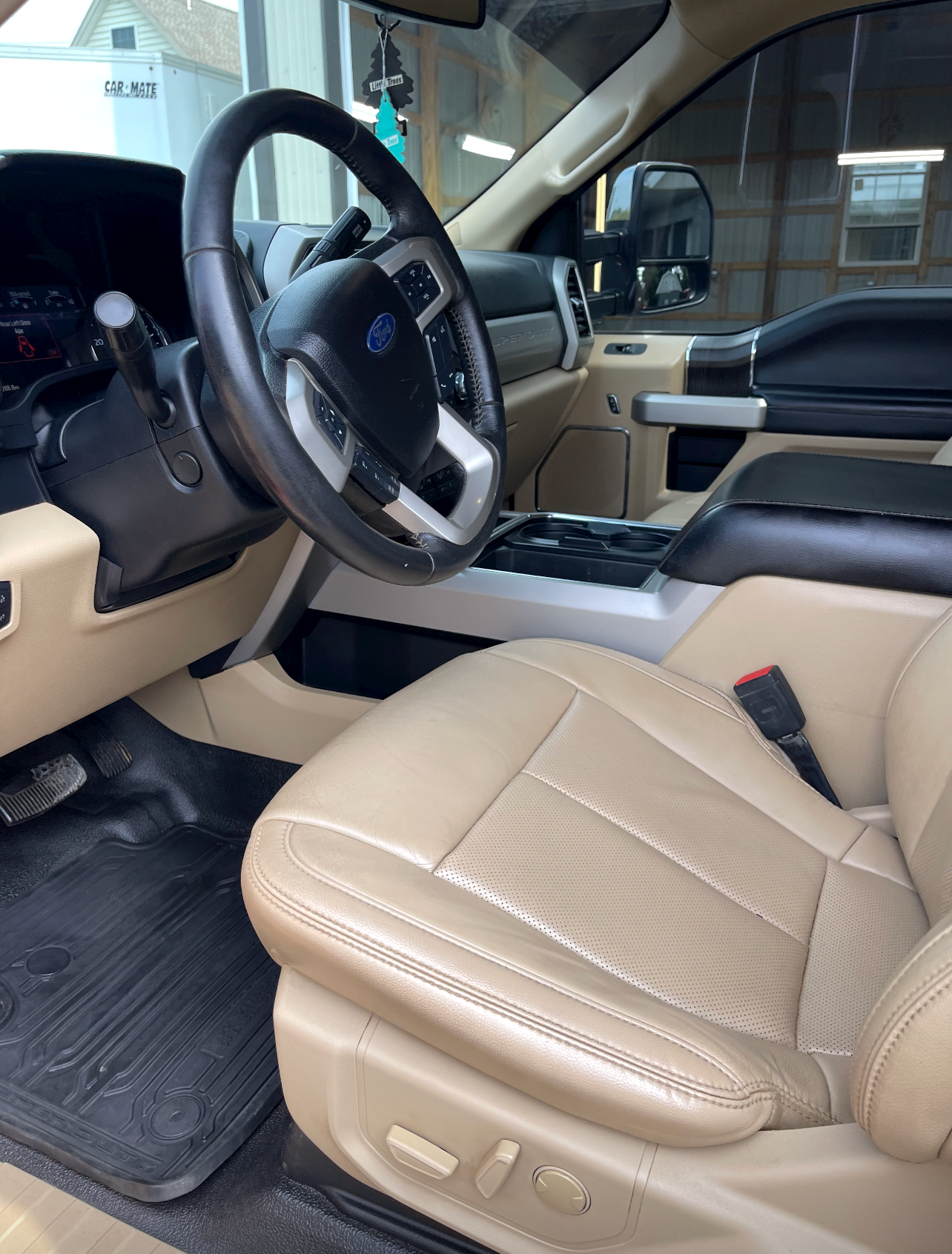 the interior of a ford truck with tan leather seats and a black steering wheel .