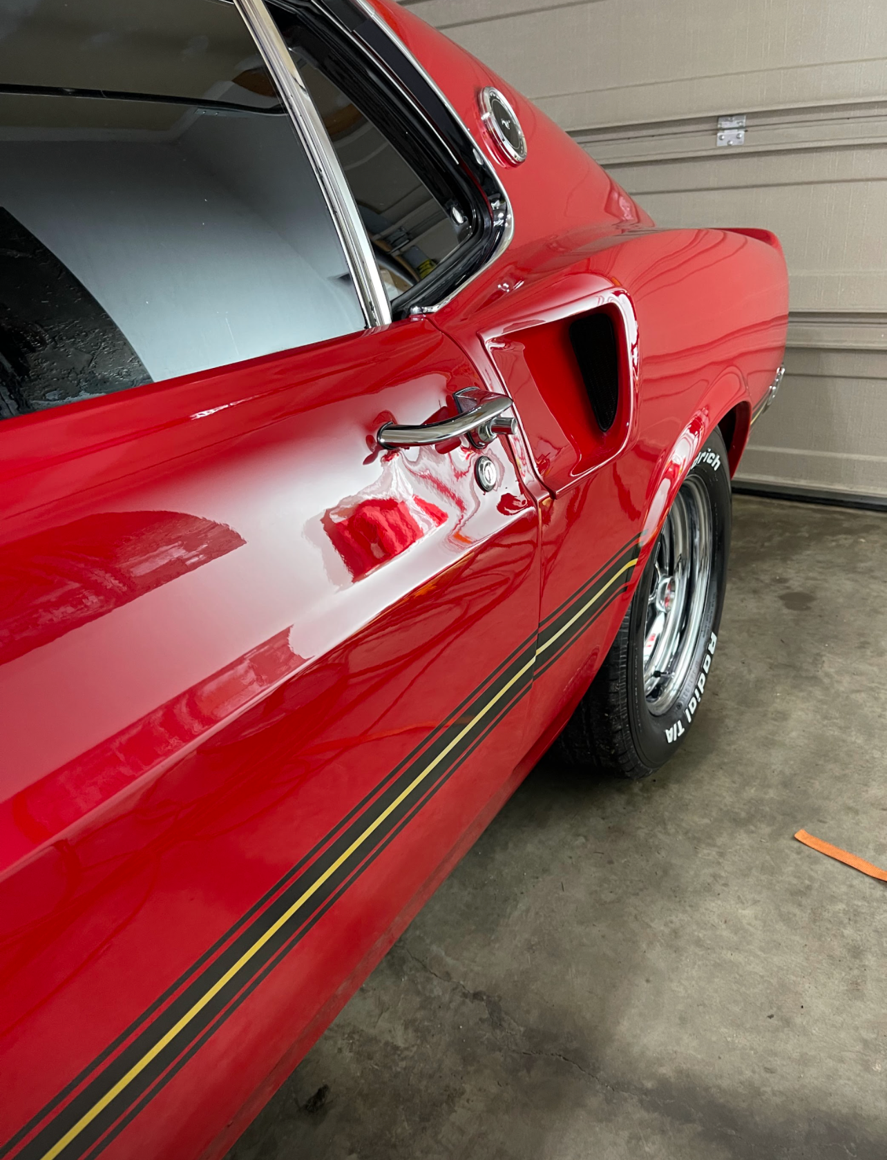 a red car is parked in a garage next to a garage door .