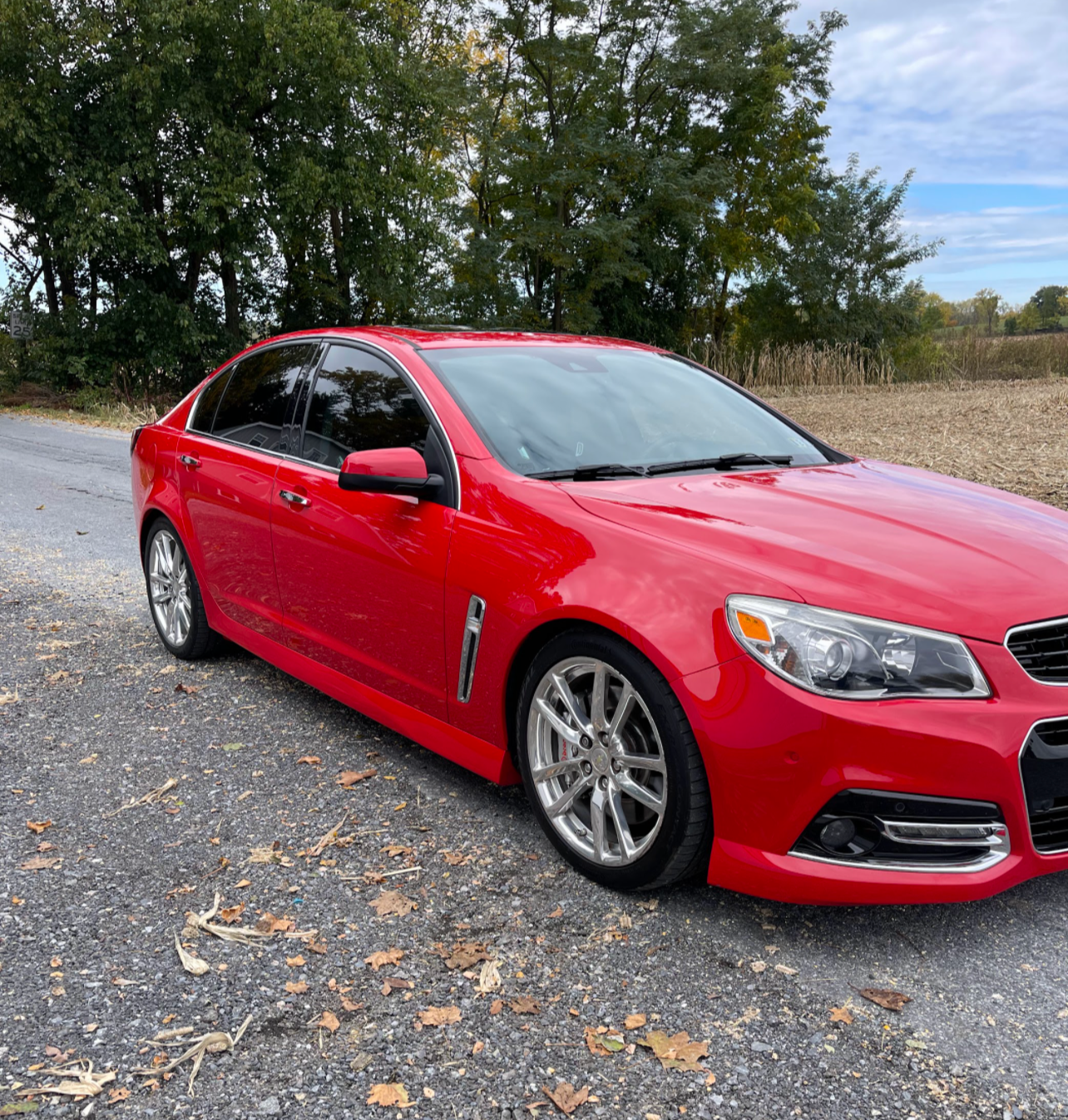 a red car is parked on the side of the road .