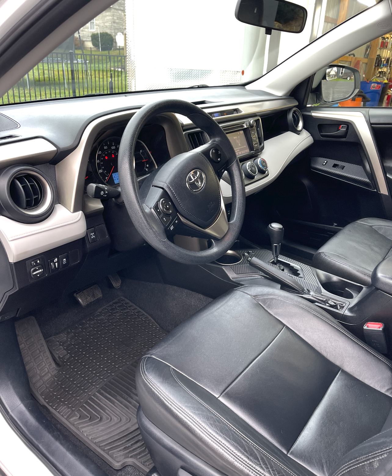 the inside of a white car with black seats and a steering wheel