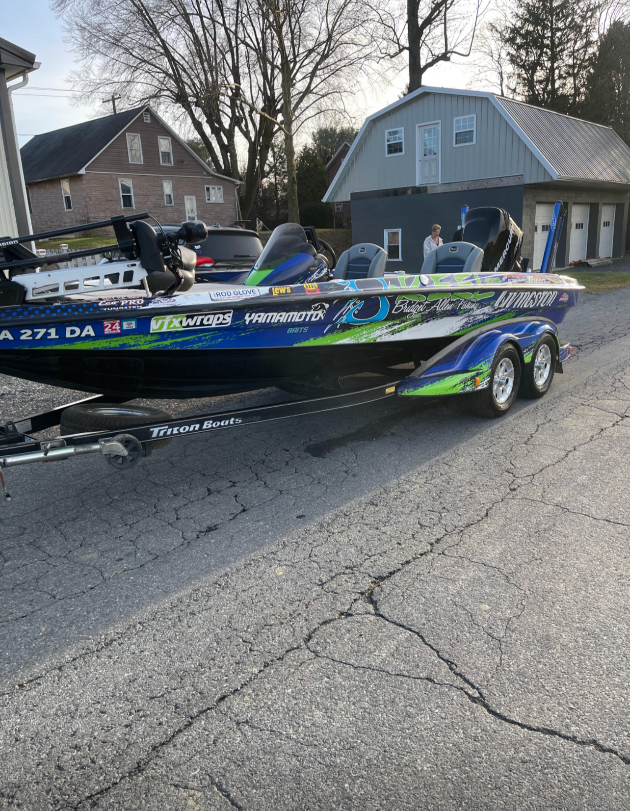 a fishing boat is parked on the side of the road next to a house .
