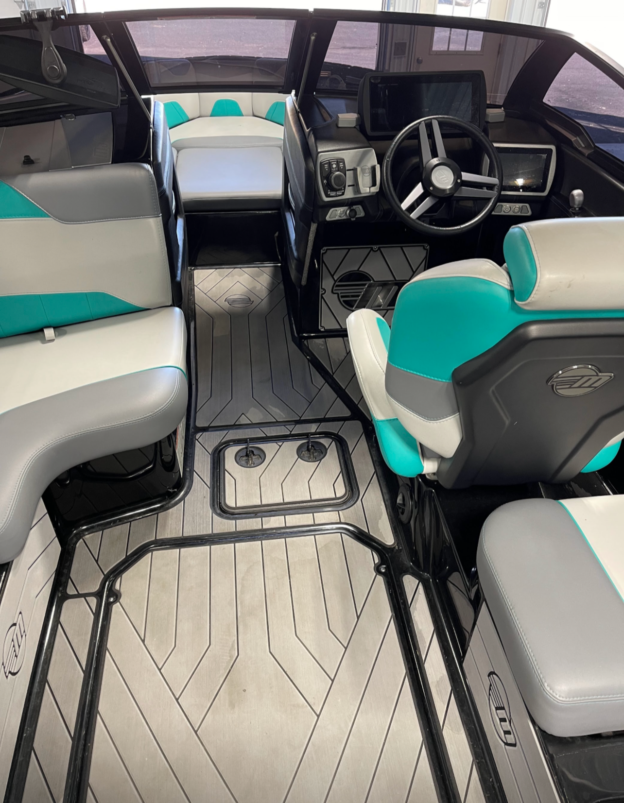 the inside of a boat with a steering wheel and seats