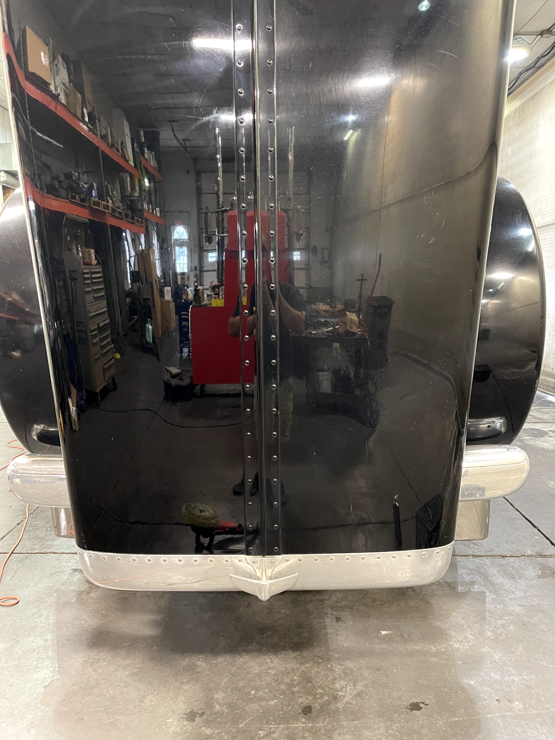 the back of a black truck is sitting in a garage .
