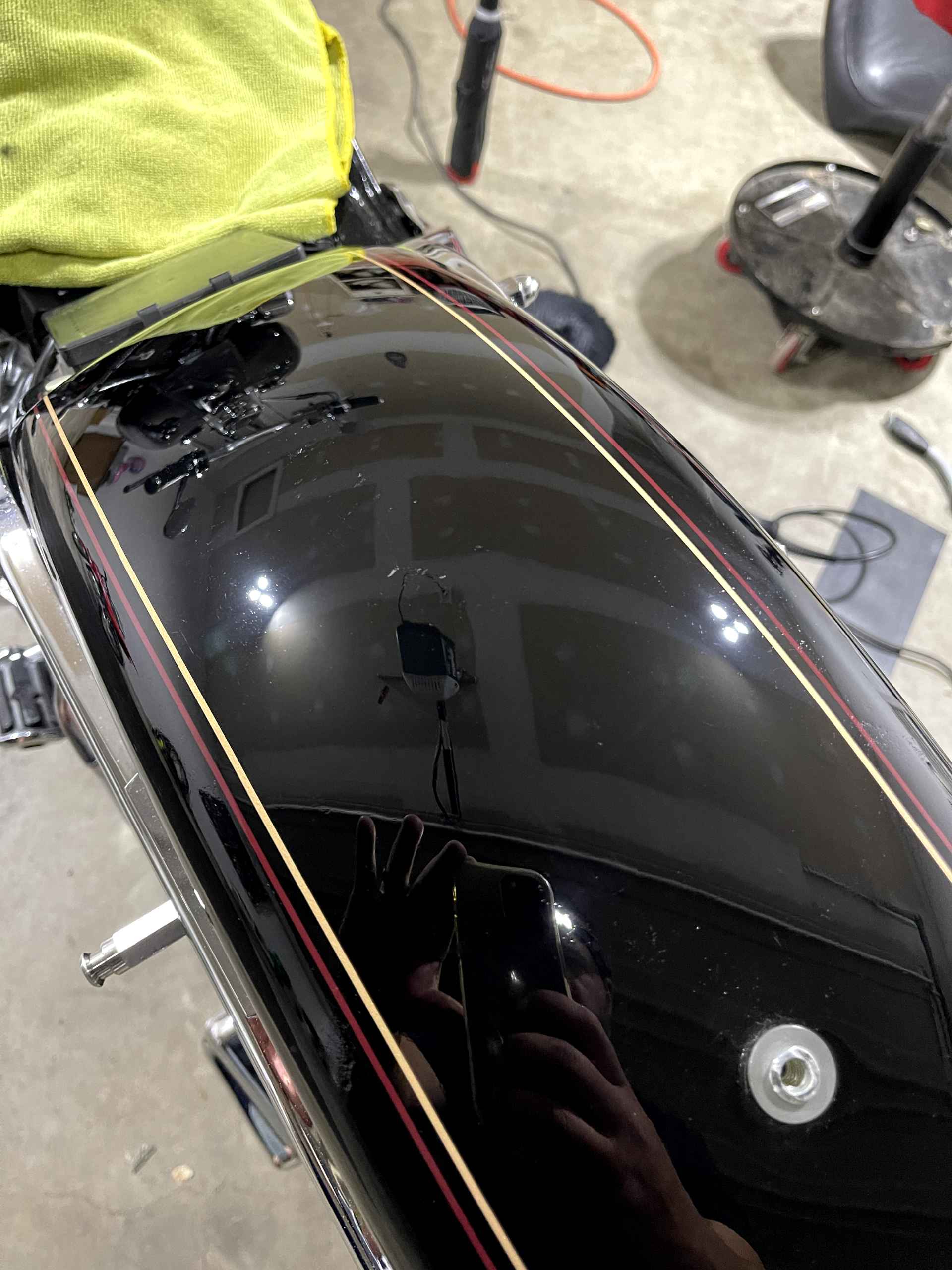 a close up of a black motorcycle with a yellow towel on the back