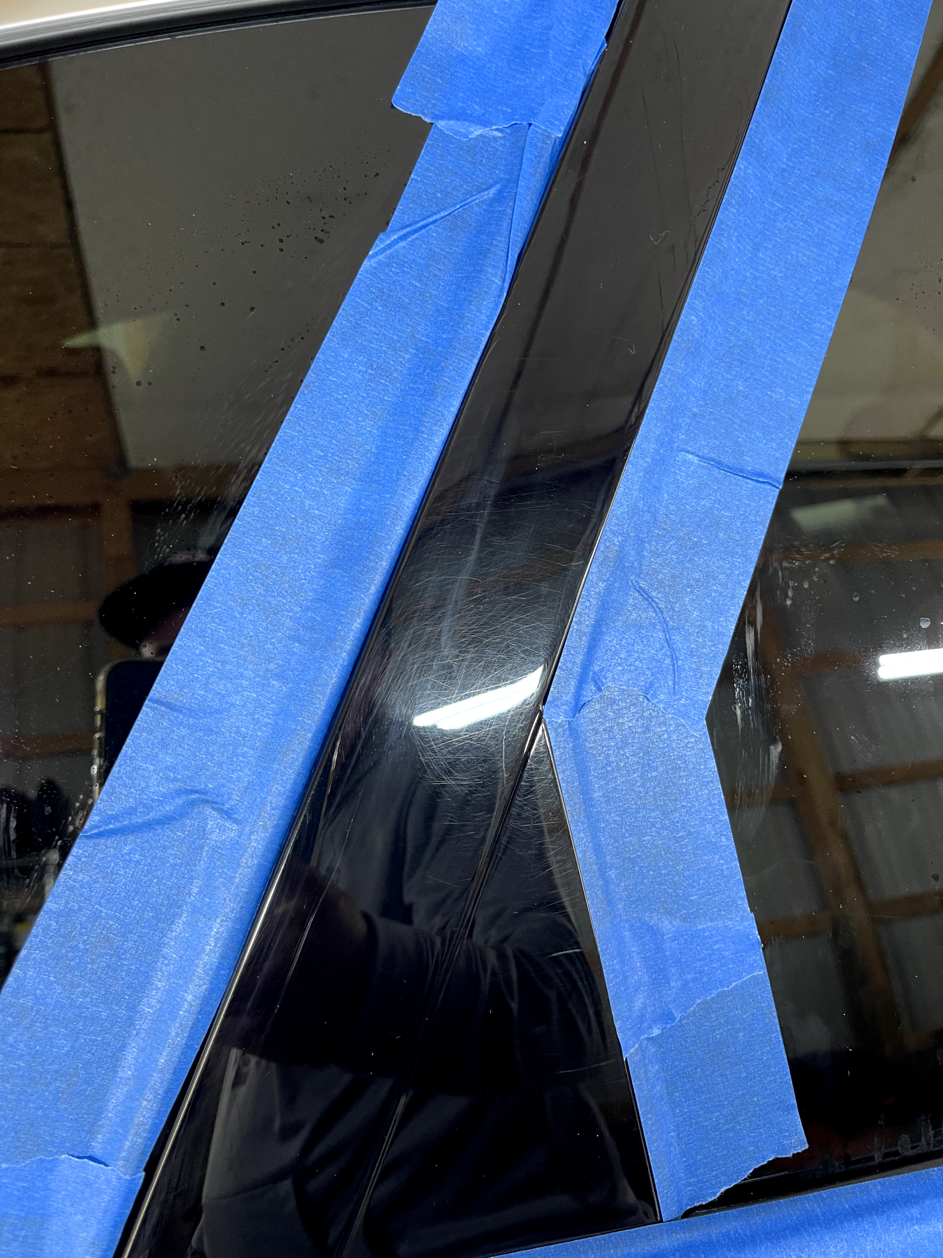 a car window is taped with blue painter 's tape