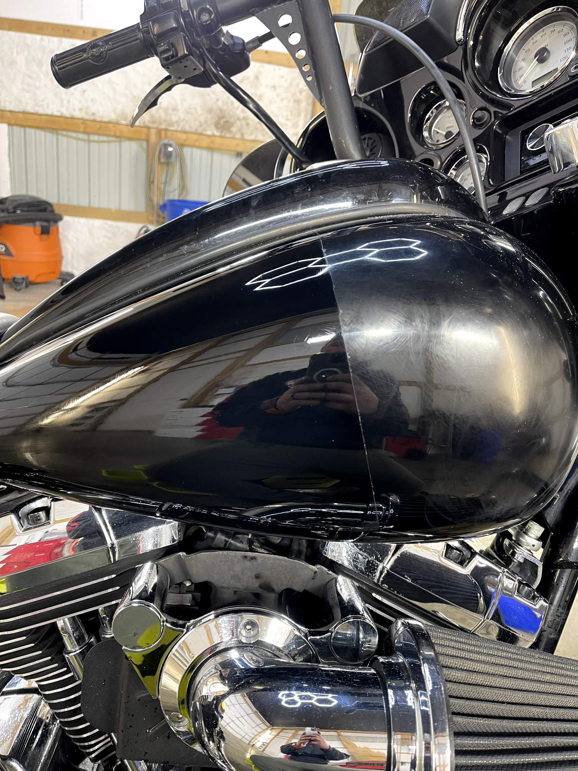 a black motorcycle is parked in a garage .