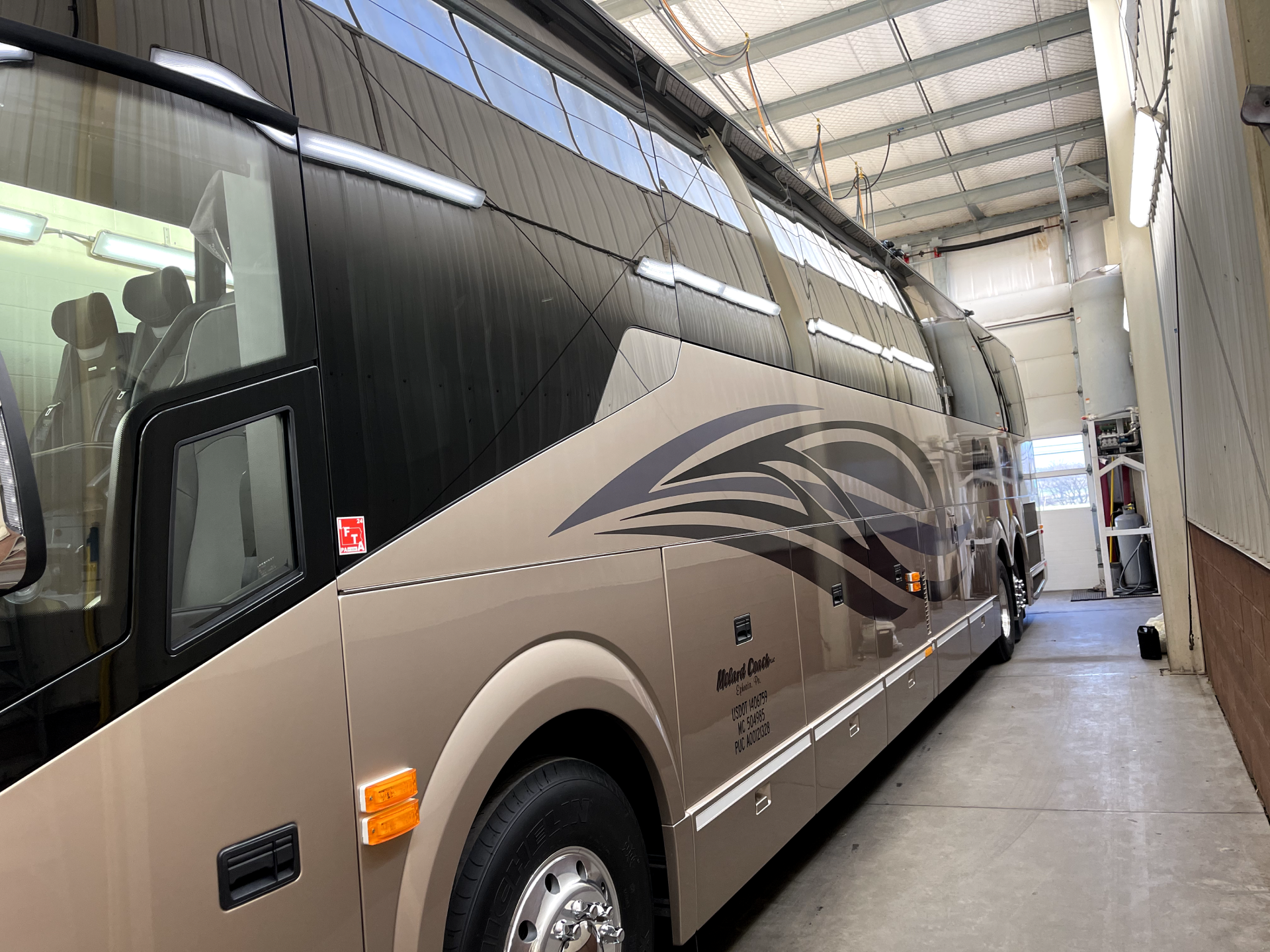 a large double decker bus is parked in a garage .
