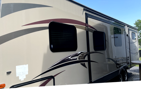 a rv is parked in a parking lot on a sunny day .