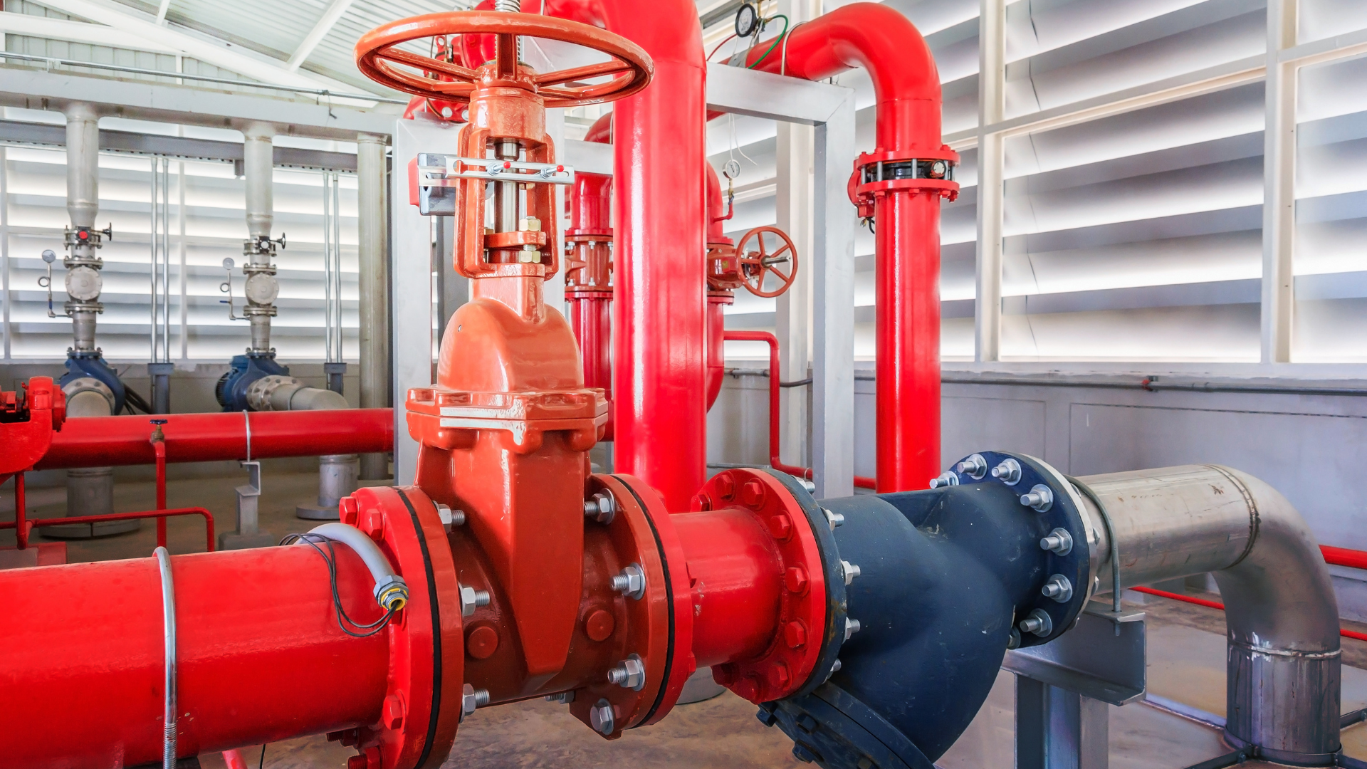 A room filled with red pipes and valves in a factory.