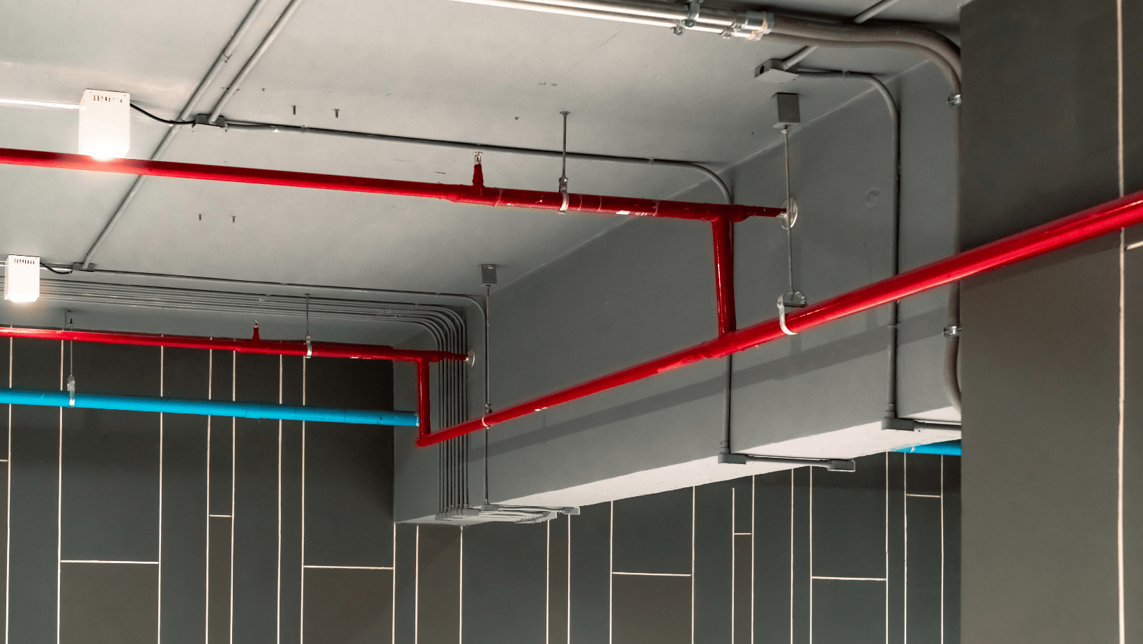 A room with red and blue pipes hanging from the ceiling.