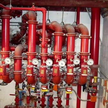 A bunch of red pipes with clocks on them